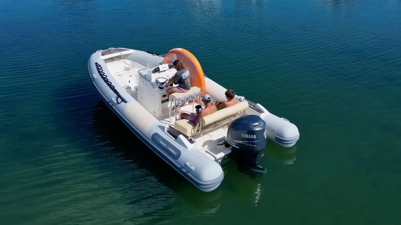 Zodiac Sea Hawk 700 — Bateau pneumatique vu de trois quarts sur l’eau, avec trois personnes à bord.