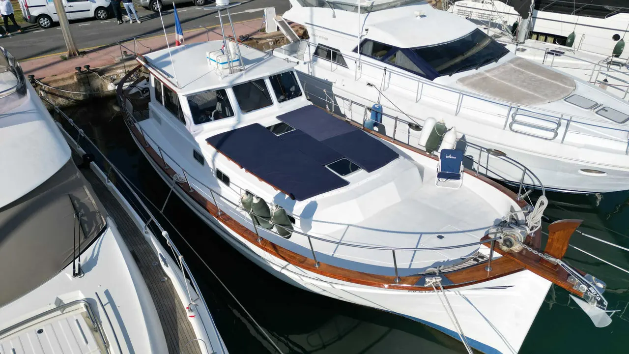 Menorquin 160 My — Vedette blanche à cabine amarrée dans un port de plaisance.
