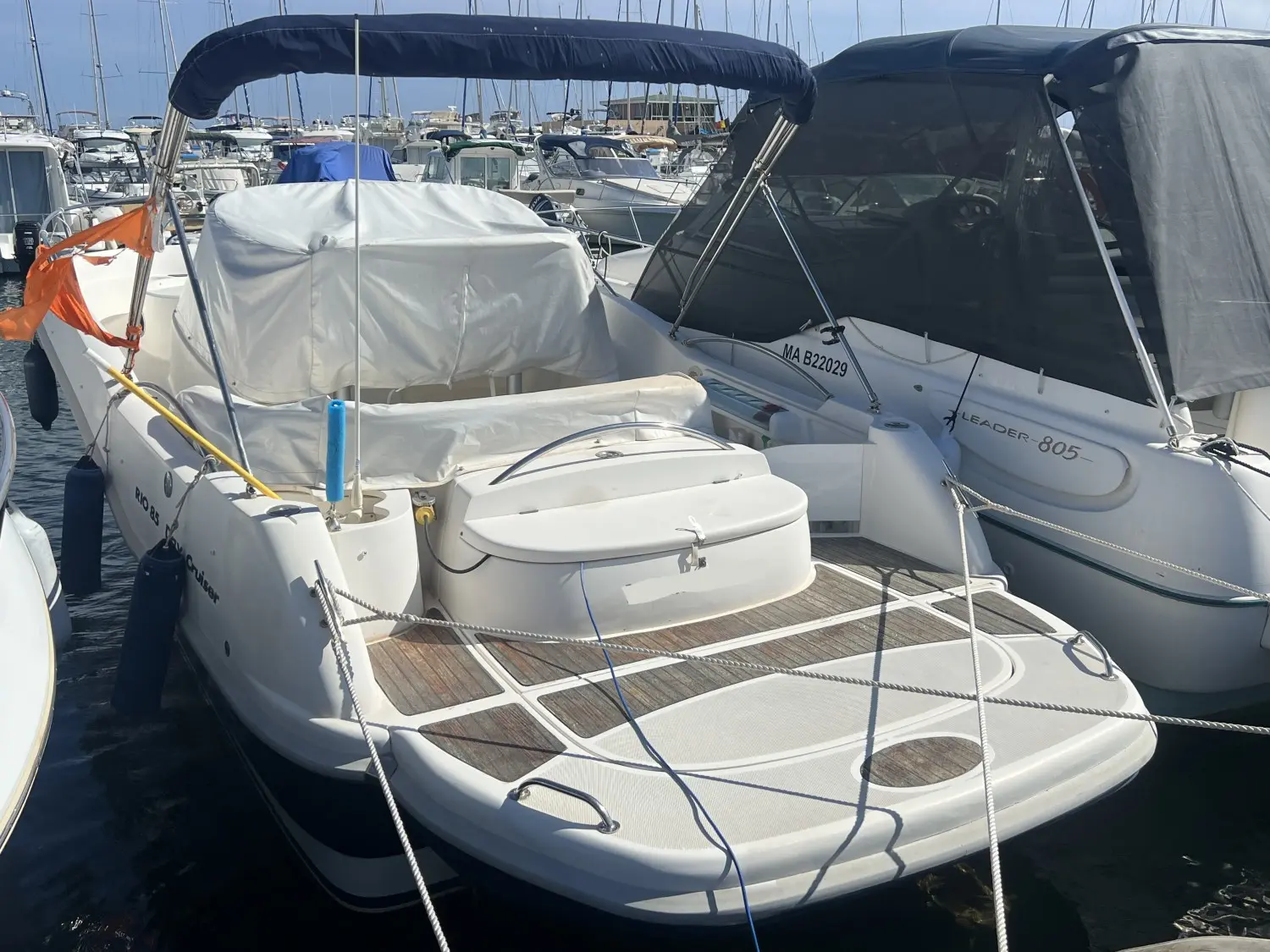 Rio 850 — Bateau à moteur blanc amarré, photographié de trois quarts arrière dans un port.