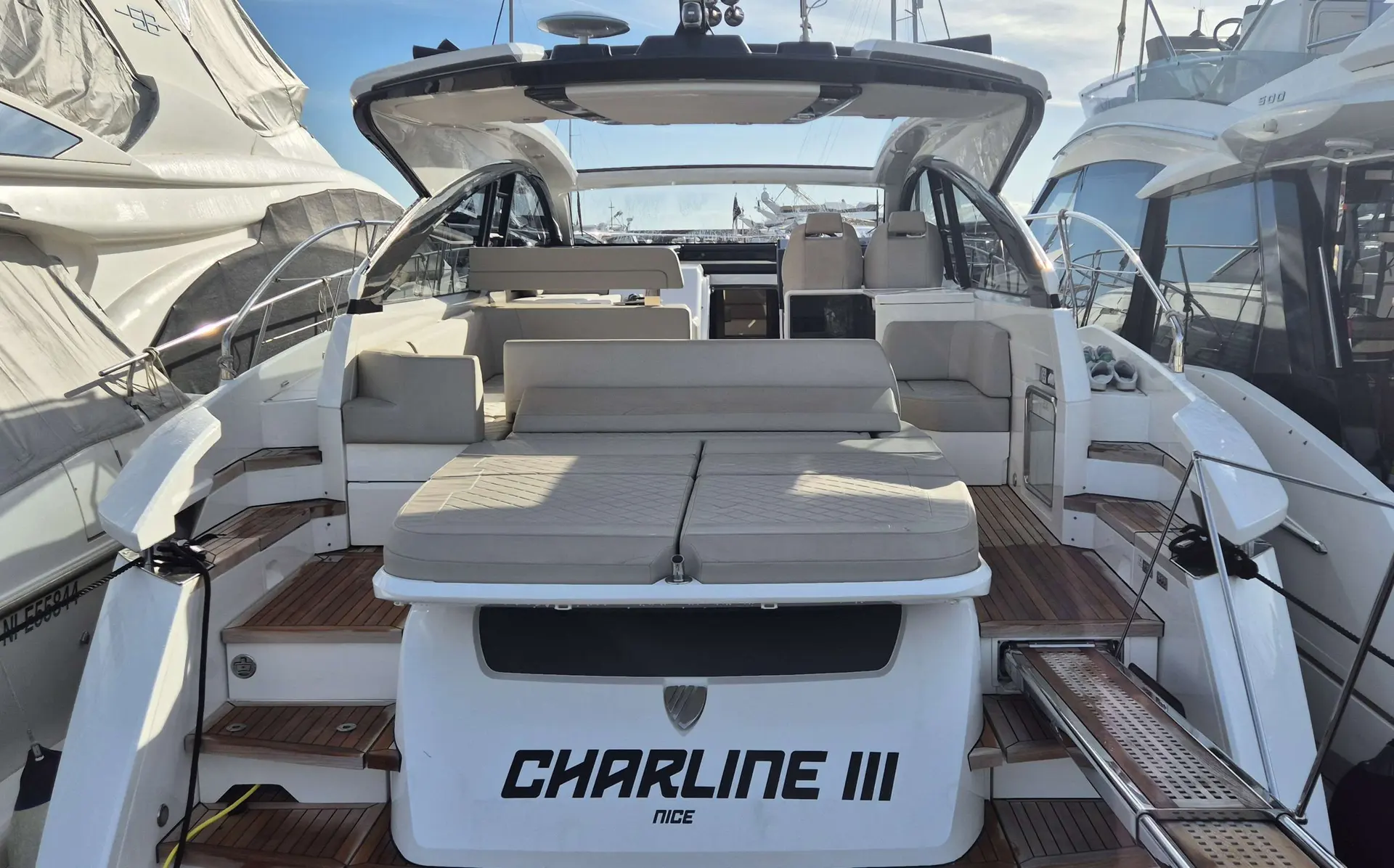 Fairline Targa 45 Open — Vue arrière du cockpit avec salon extérieur, bain de soleil et passerelle.