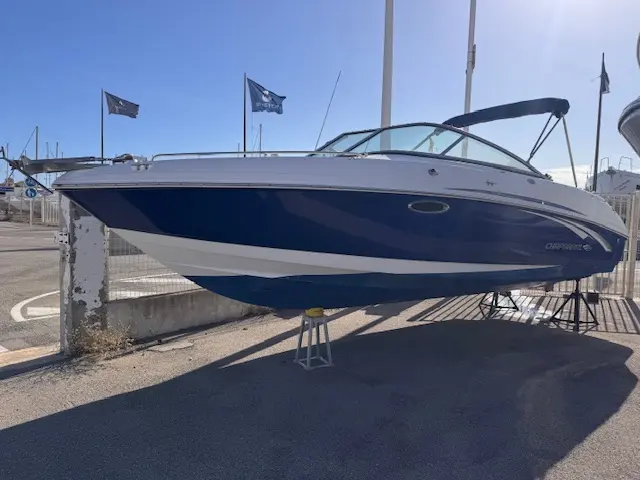 Chaparral 246 SSi WT — Bateau à moteur bleu et blanc présenté sur un ber, vu de trois quarts à terre.