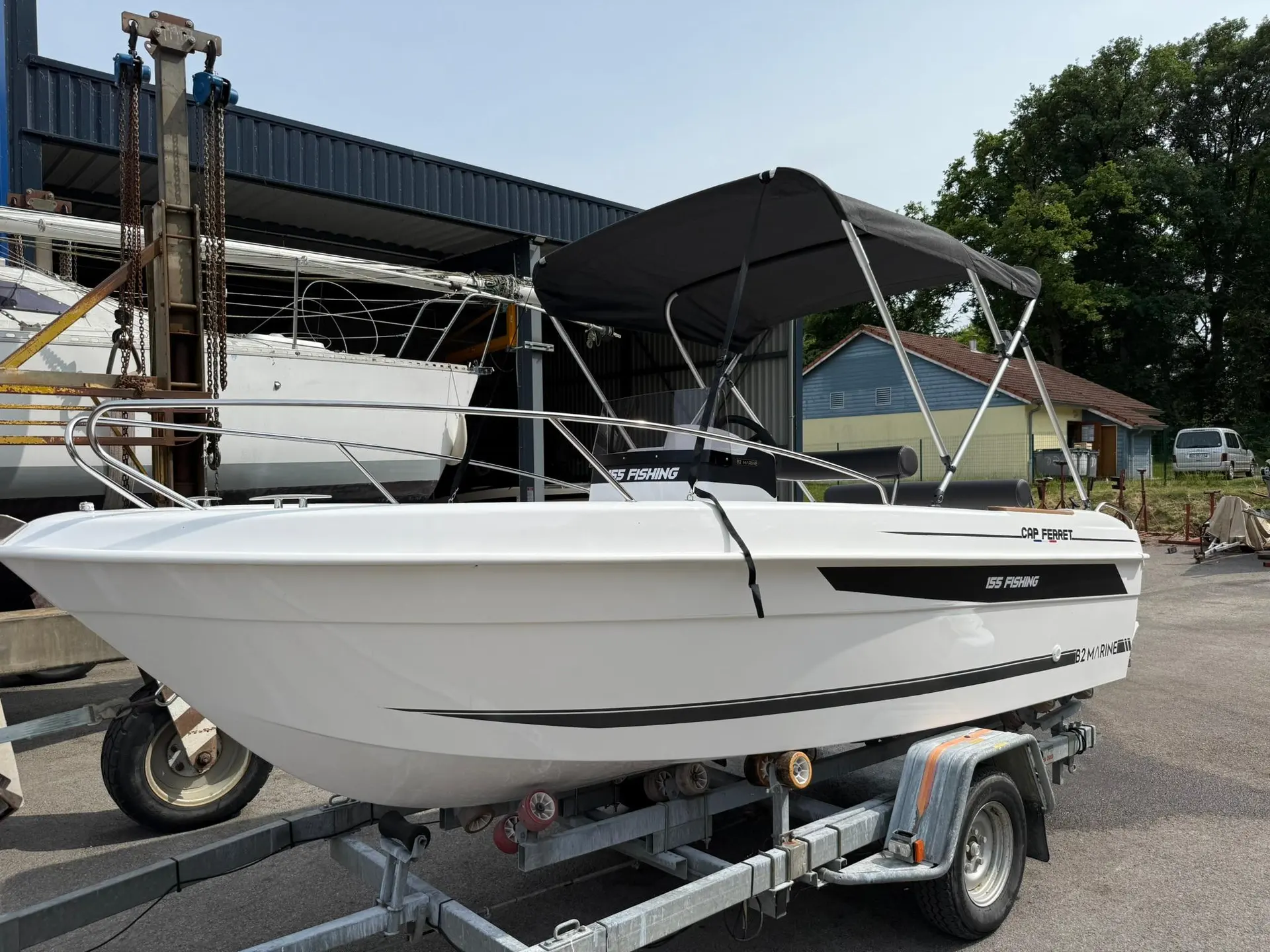B2 Marine 155 — Bateau blanc à console centrale et taud noir, présenté sur une remorque.