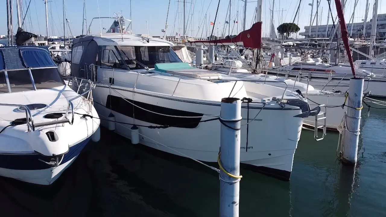 Delphia 1100 — Bateau à moteur blanc amarré dans un port de plaisance, vu de trois quarts avant.