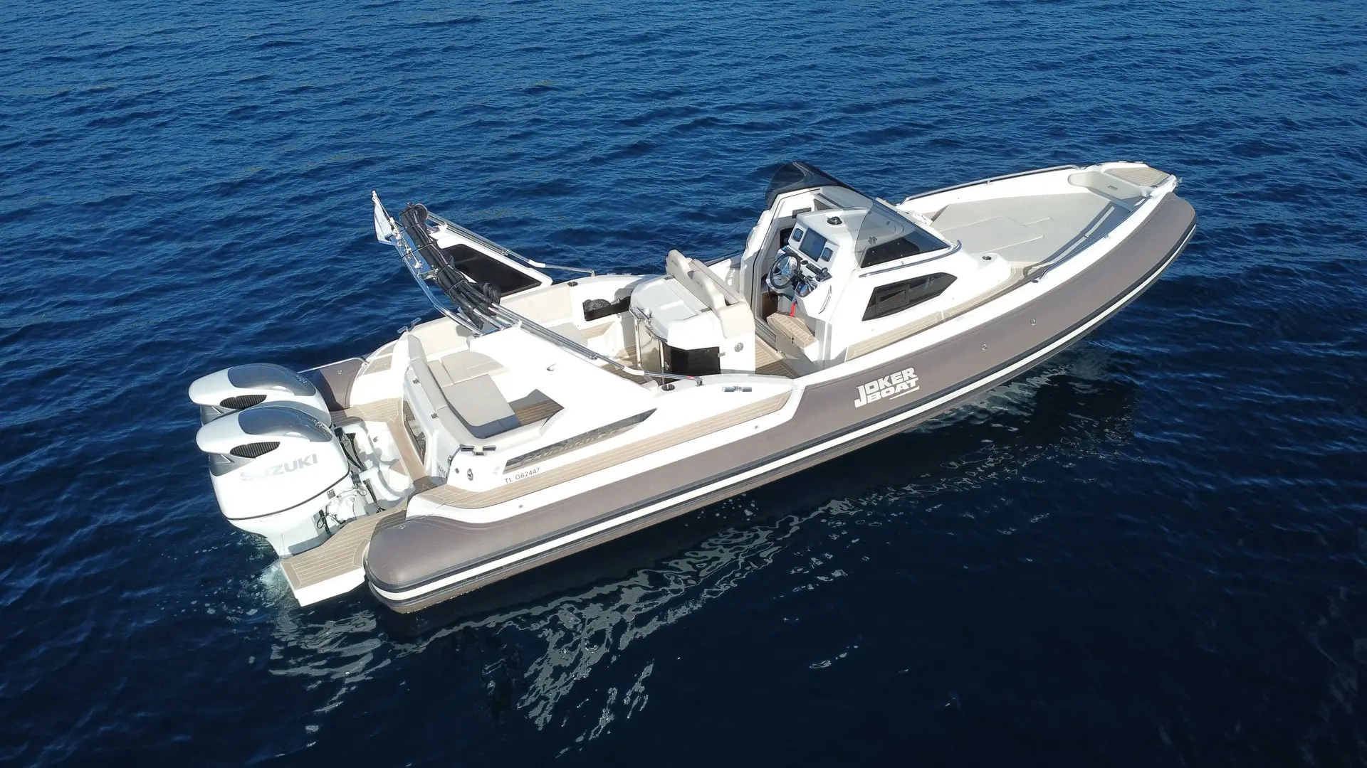 Joker Boat Clubman 32 — Bateau semi-rigide blanc et gris vu en trois-quarts arrière sur la mer.