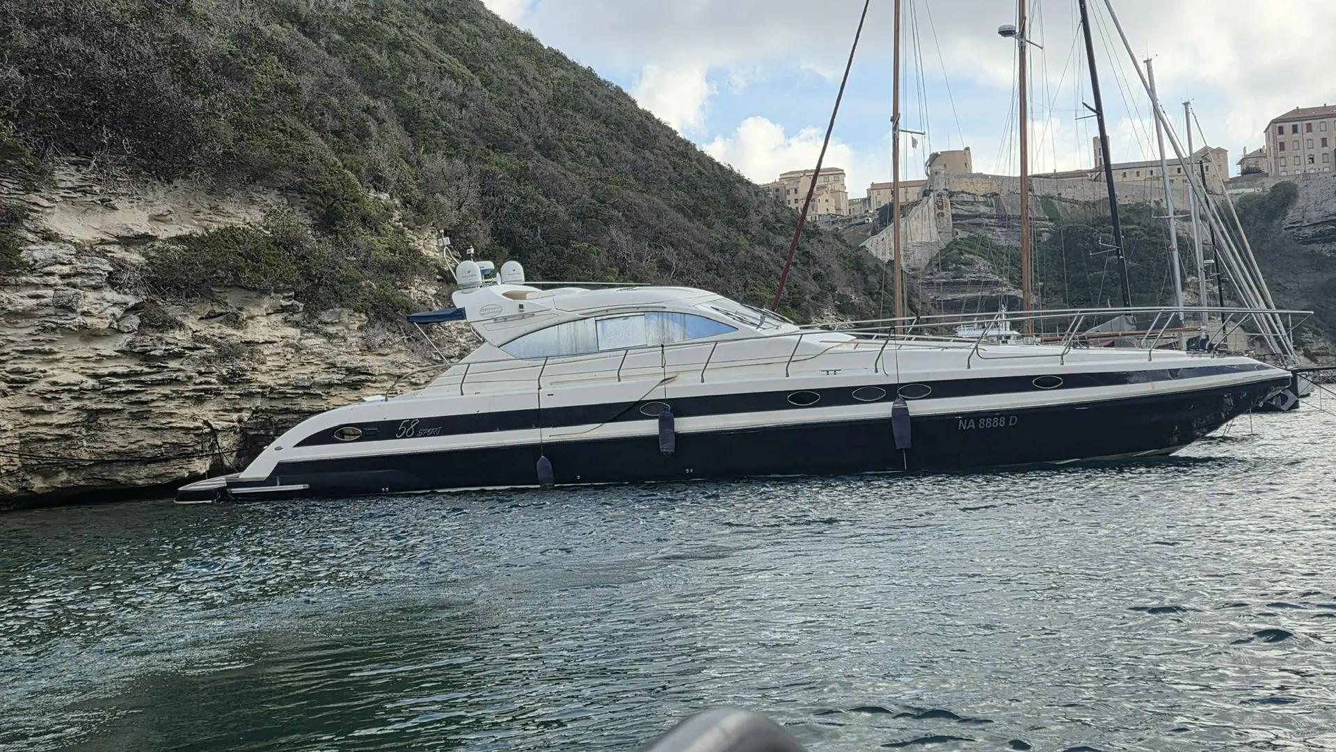 Conam 58 Sport — Bateau à moteur vu de profil dans une crique, près d'une côte rocheuse.