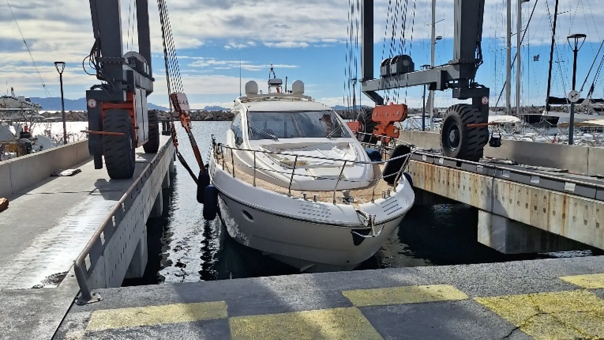 Queens Yachts 54 — Bateau à moteur vu de face dans un bassin de levage au port.