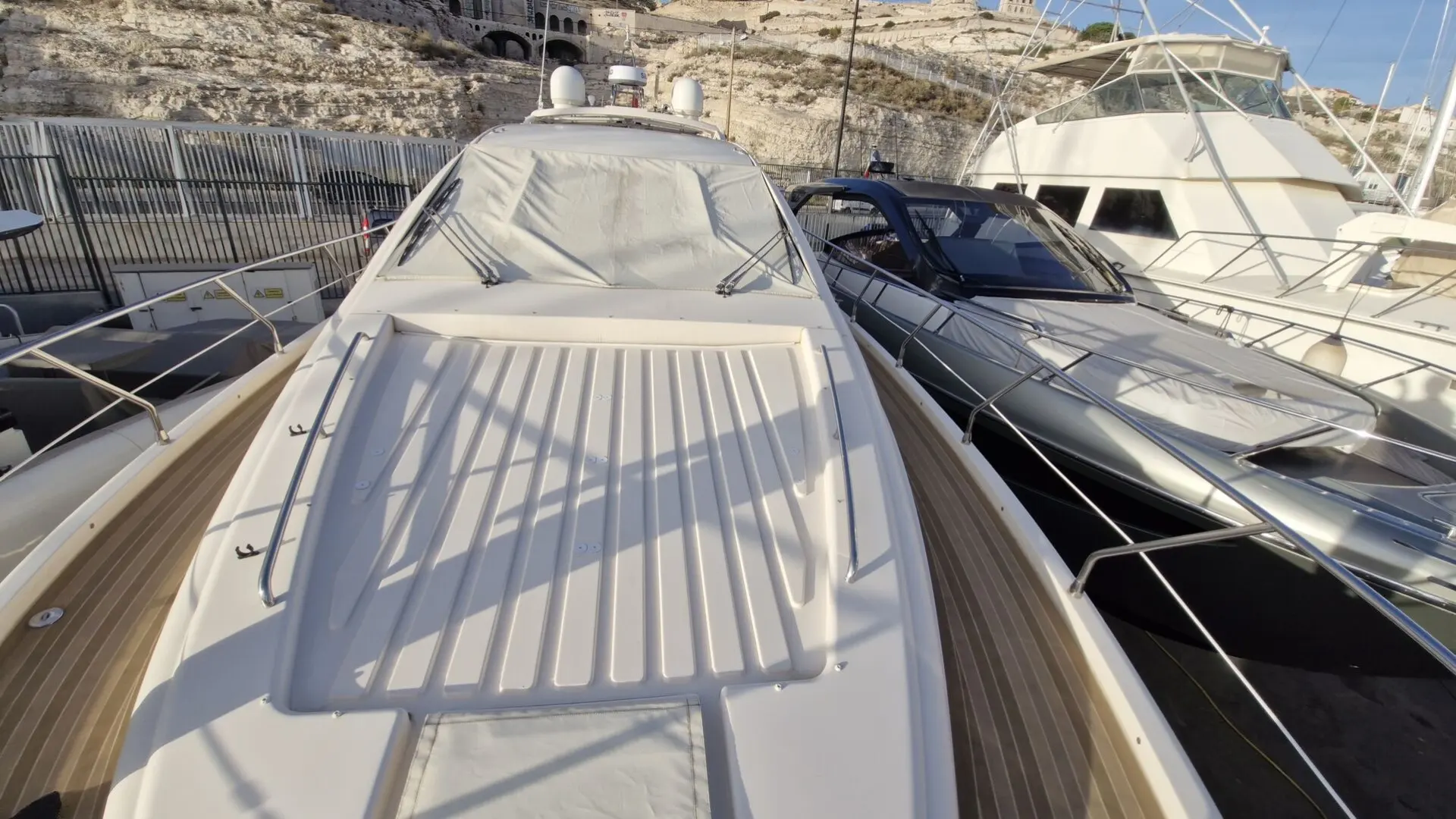 Queens Yachts 54 — Vue avant du pont et du pare-brise d’un bateau amarré dans une marina.