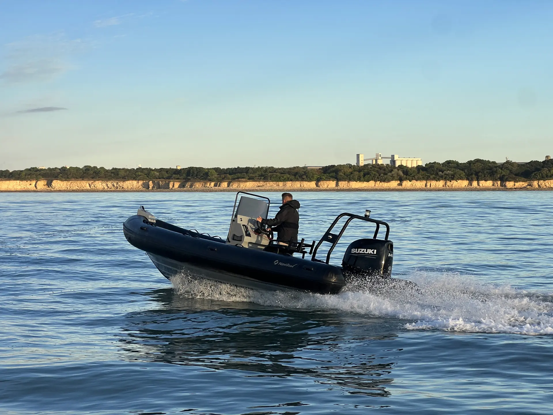 Navisoul 650 — Bateau semi-rigide naviguant près d’une côte rocheuse, avec une personne à la barre.