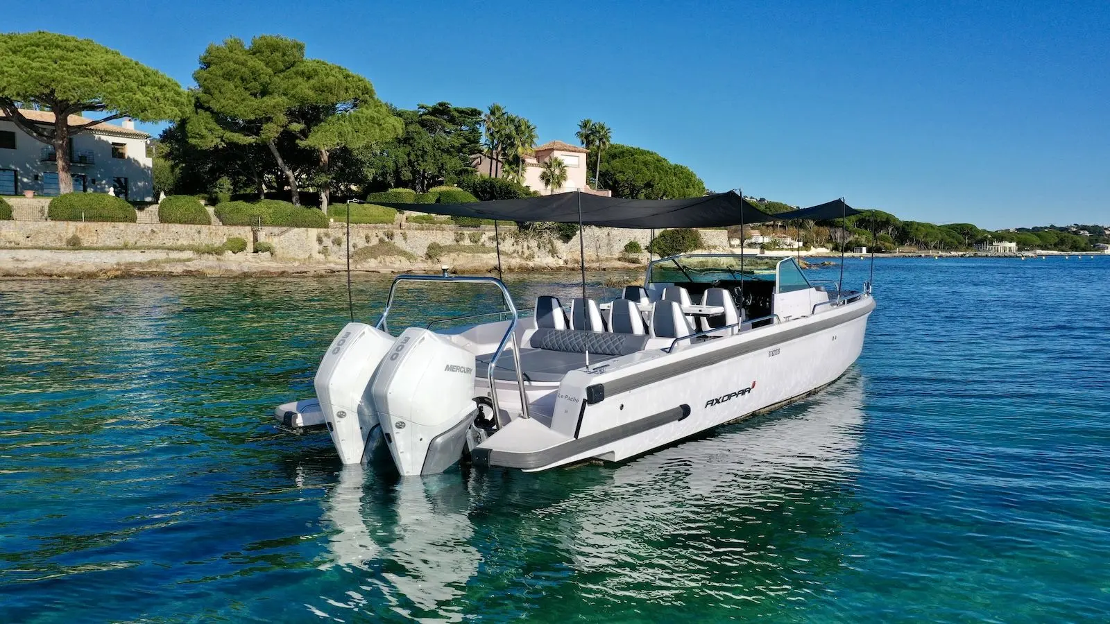 Axopar 37 Spyder — Bateau à moteur blanc amarré, photographié de trois quarts arrière.