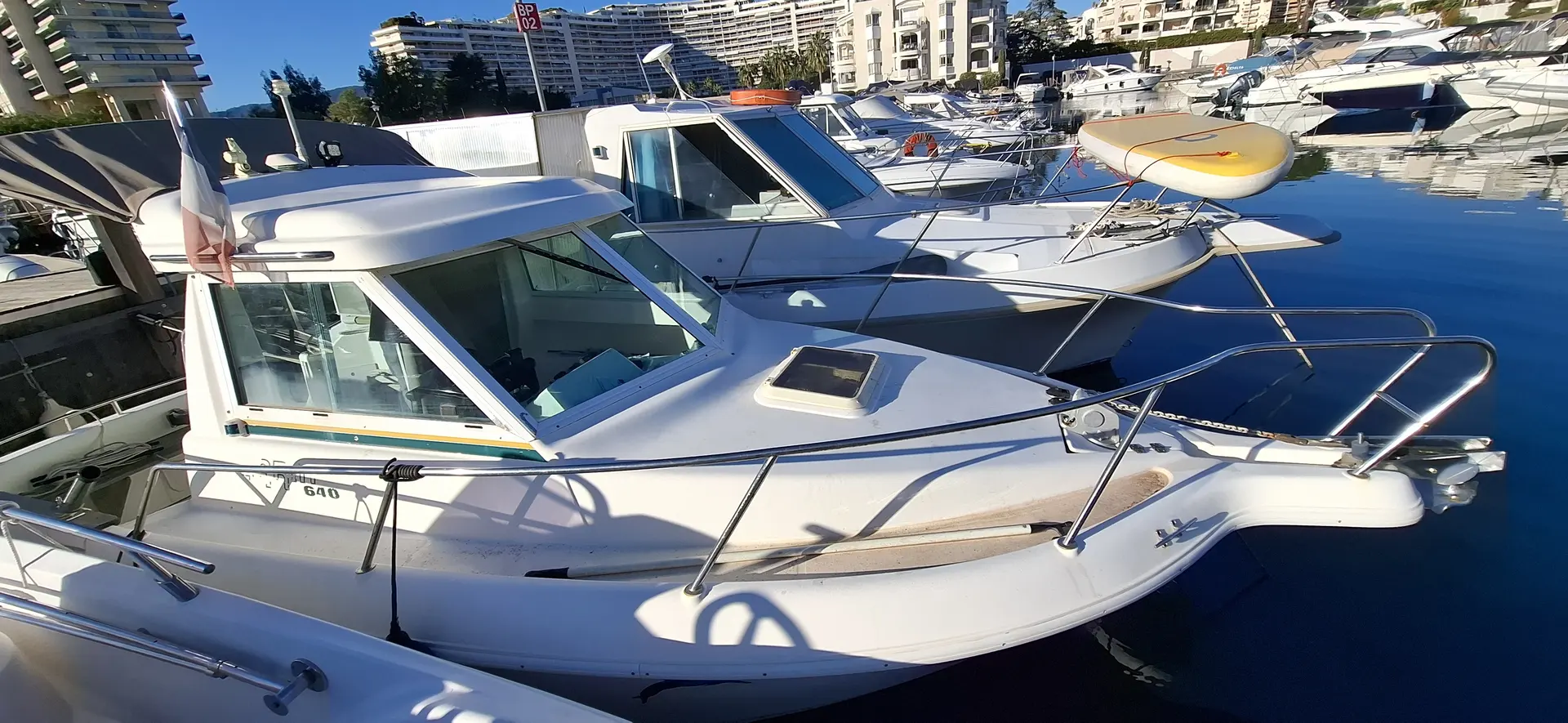 Garin 640 — Bateau à moteur blanc amarré dans un port, vu de trois quarts avant.