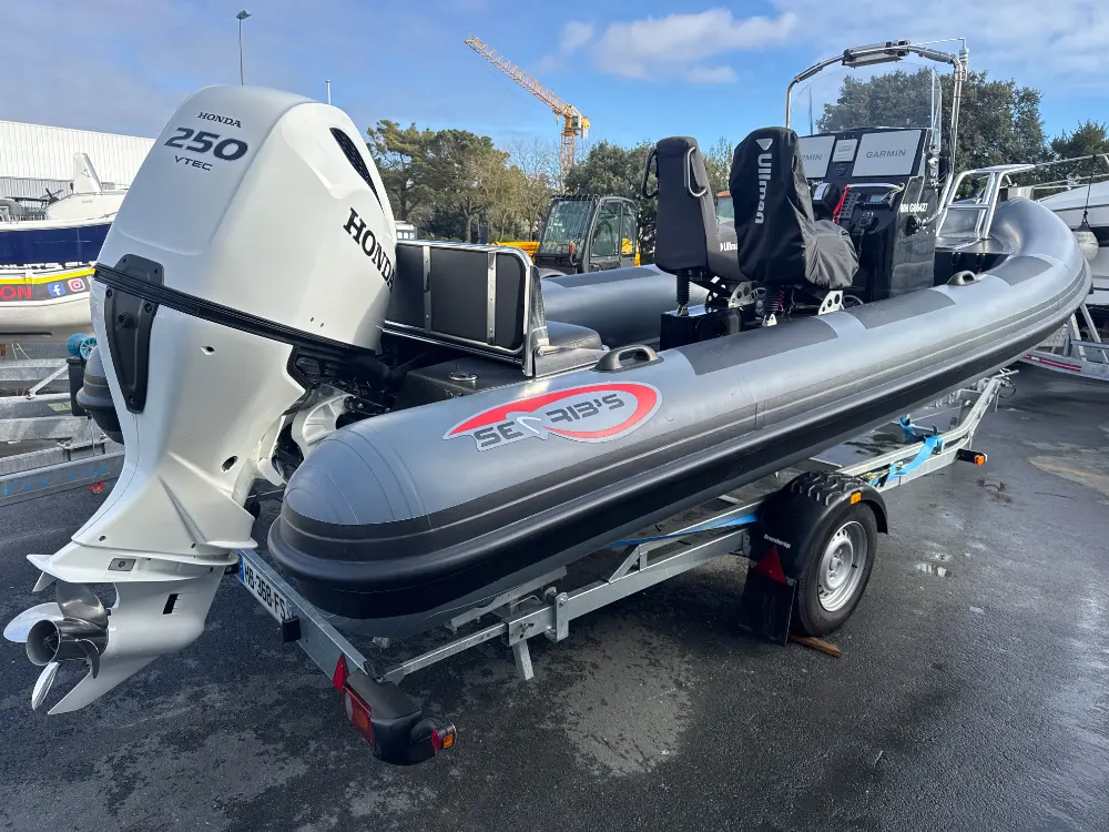 Searib`s Open 670 — Bateau pneumatique gris présenté sur remorque, équipé d’un moteur hors-bord Honda.