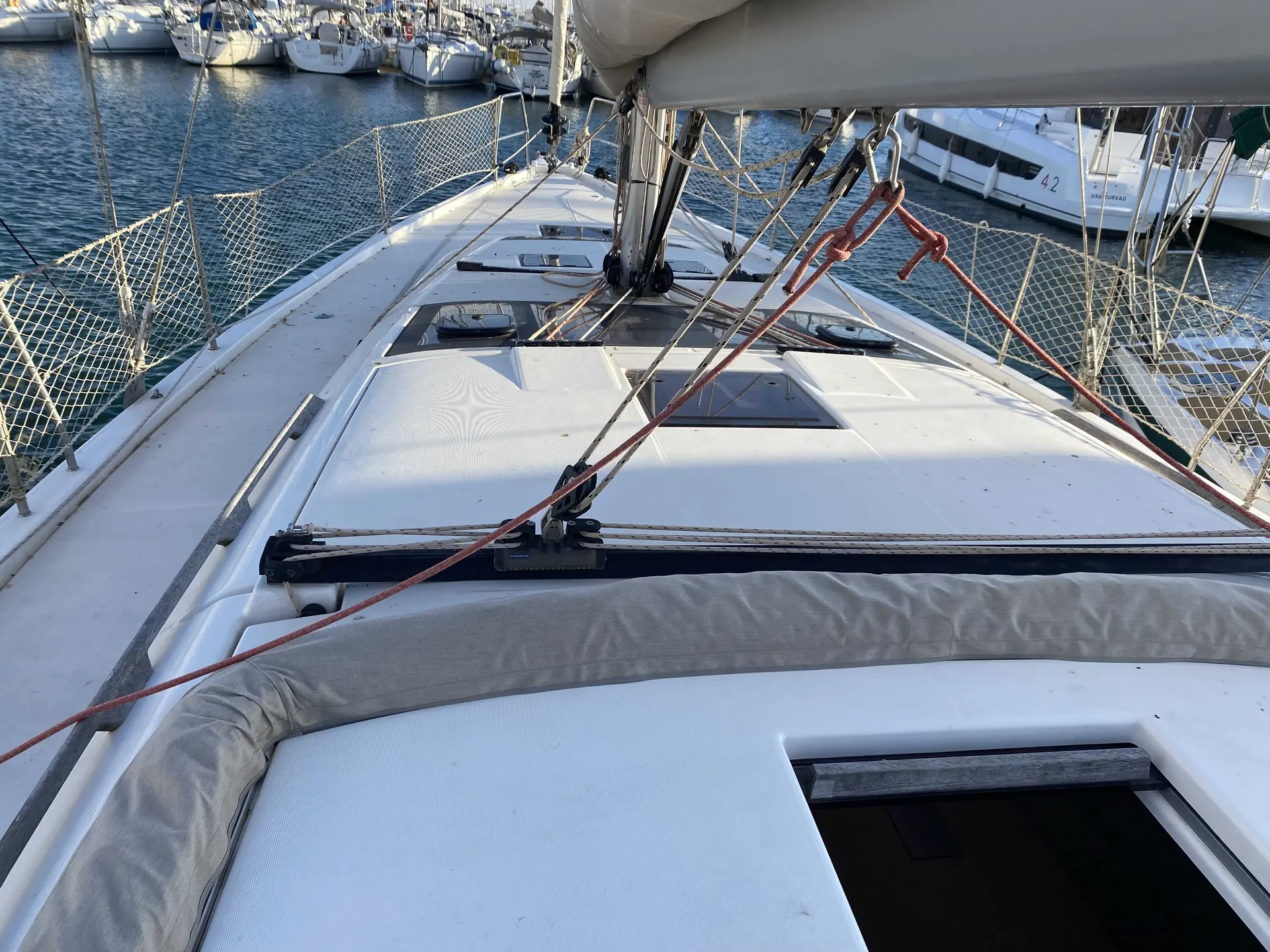 Dufour 430 Grand Large — Vue du pont avant d’un voilier amarré, avec gréement et filets de protection.