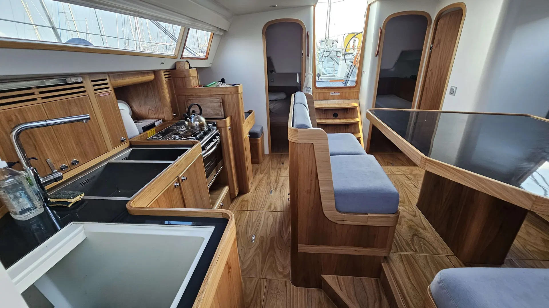 Futuna Yachts Futuna 50 — Vue intérieure montrant la cuisine et le carré aménagés en bois.