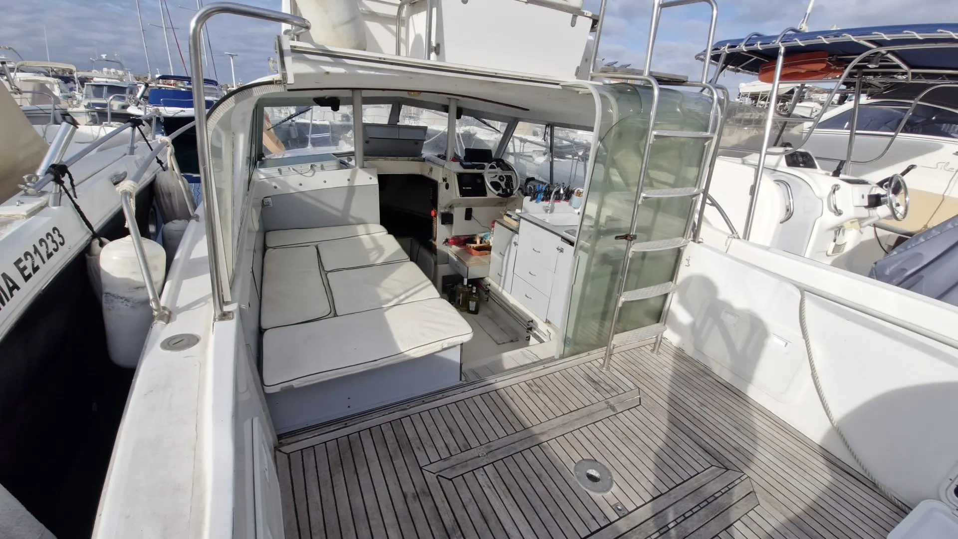 Bertram 25 — Vue du cockpit arrière avec banquette, poste de pilotage et rangements.