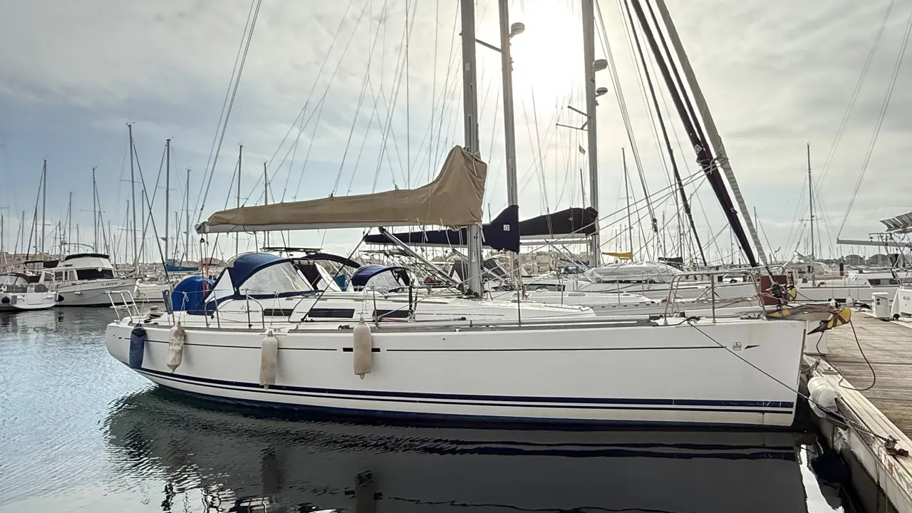 Dufour 40 PERFORMANCE — Voilier blanc amarré dans une marina, vu de profil.