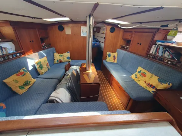 Bruce Roberts 45 Spray — Salon intérieur en bois avec banquettes bleues et coussins décoratifs.