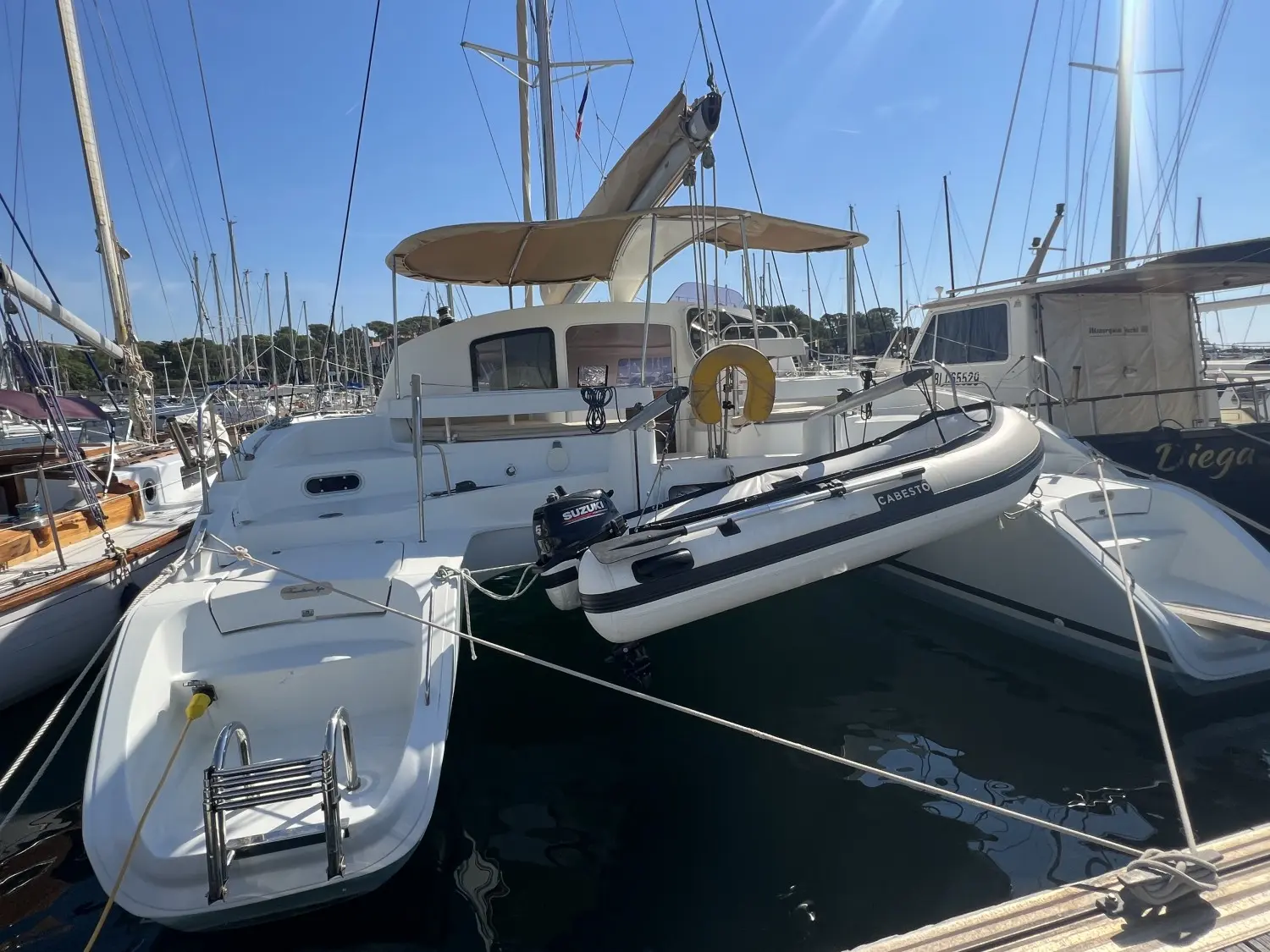 Fountaine Pajot Lavezzi 40 — Catamaran blanc vu de l’arrière dans un port, avec annexe suspendue.