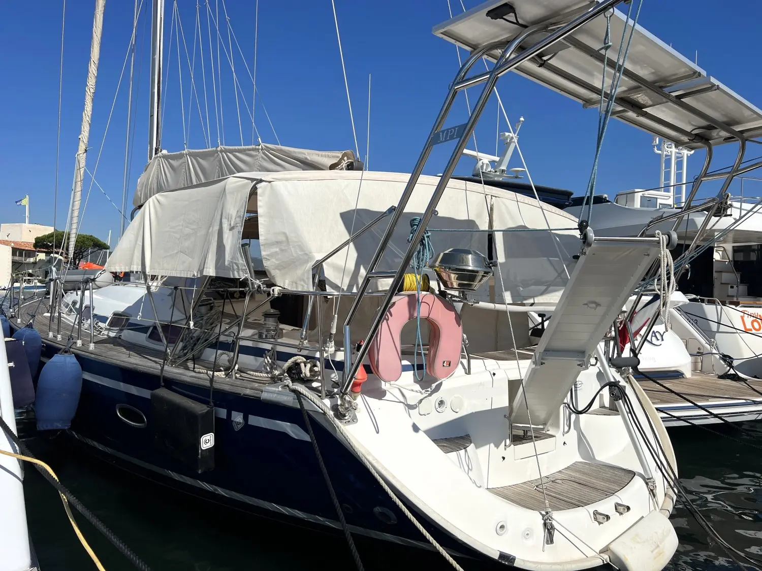 Bavaria 50 — Voilier amarré vu de trois quarts arrière, avec tauds, gréement et passerelle.