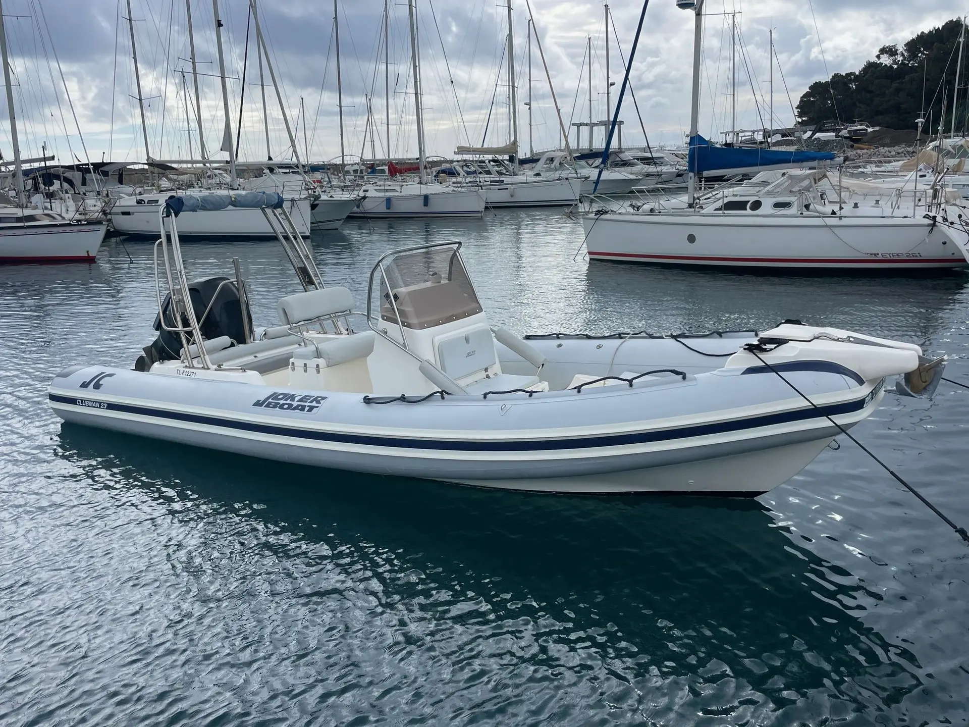 Joker Boat Clubman 23 — Bateau pneumatique blanc amarré dans un port, vu de trois quarts.