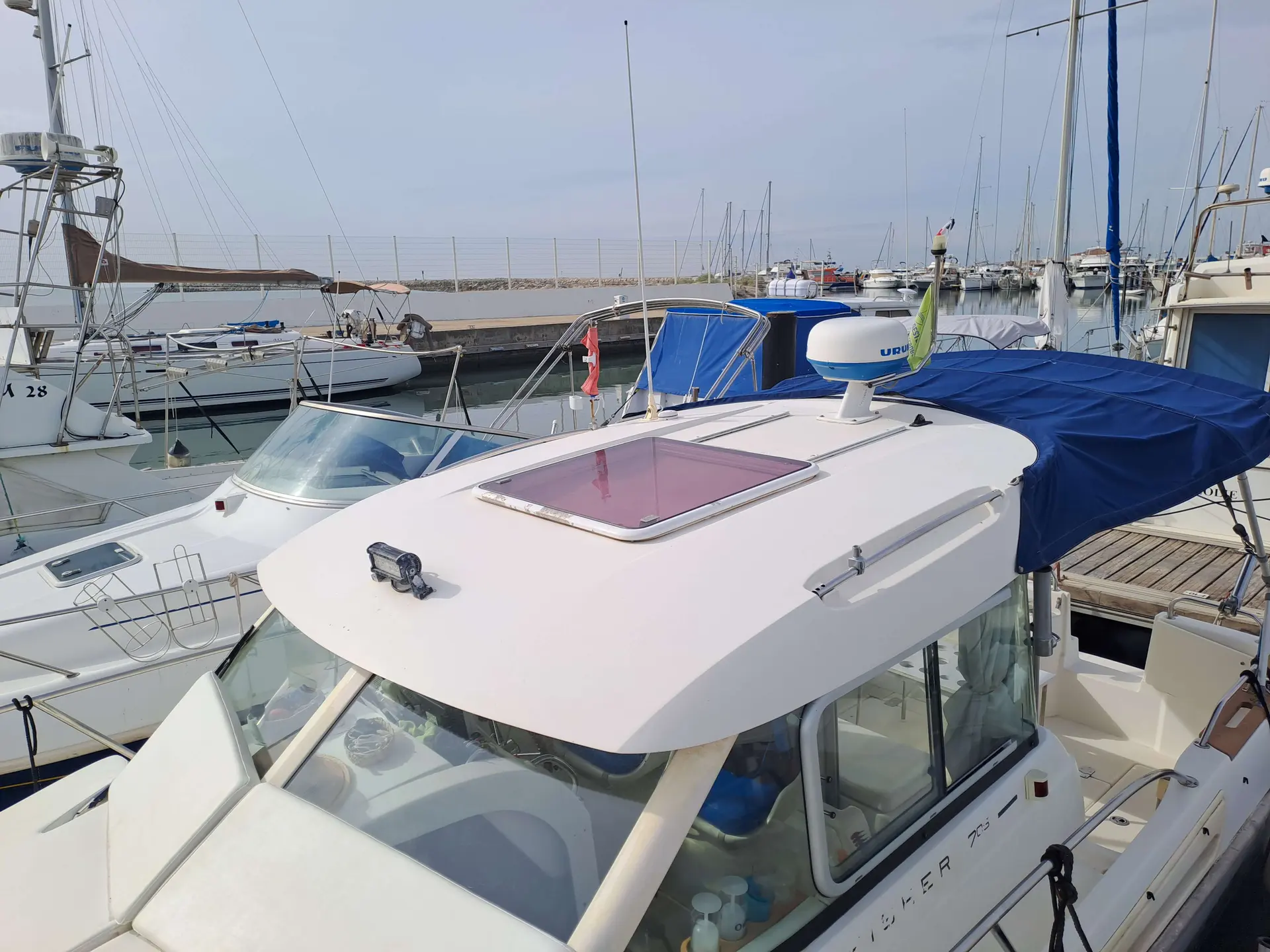 Jeanneau Merry Fisher 705 — Vue rapprochée du toit et du poste de pilotage d’un bateau au port.