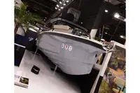 Axopar 29 XC CROSS CABIN — Bateau présenté sur un stand d’exposition, vu de trois quarts avant.