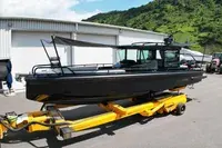 Brabus Marine Shadow 500 — Bateau à moteur noir vu de trois quarts sur une remorque dans une cour.