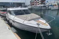 Aquador 28 HT — Bateau à moteur vu de trois quarts, amarré dans un port.