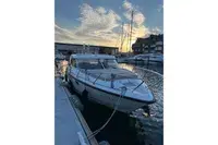 Aquador 28 HT — Bateau amarré dans une marina, vu de trois quarts avant.