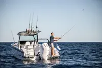 Axopar 29 CCX — Bateau vu de l’arrière en mer, avec deux personnes à bord.