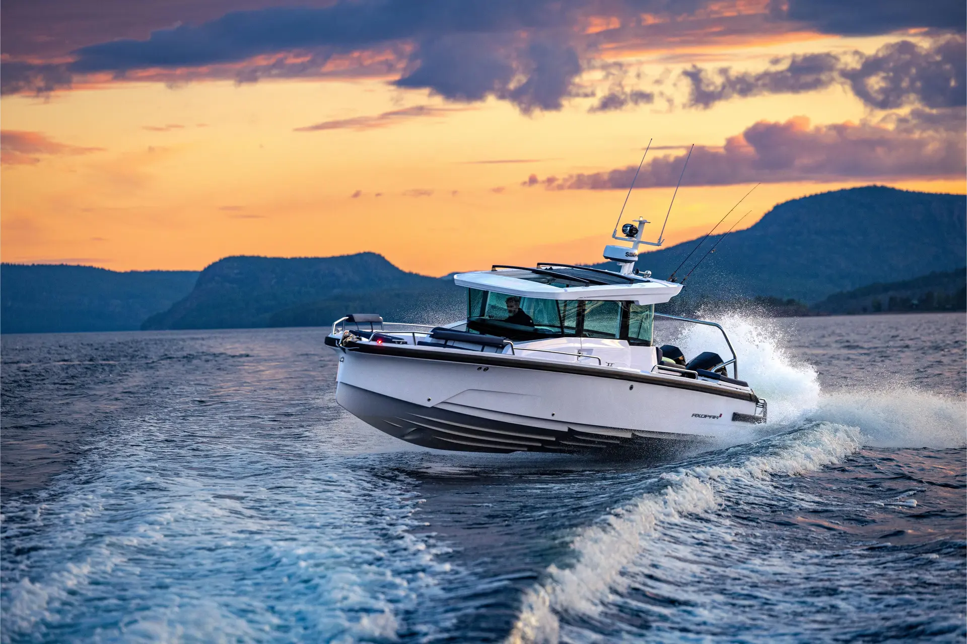 Axopar 29 XC CROSS CABIN — Bateau à moteur blanc naviguant sur un lac au coucher du soleil.
