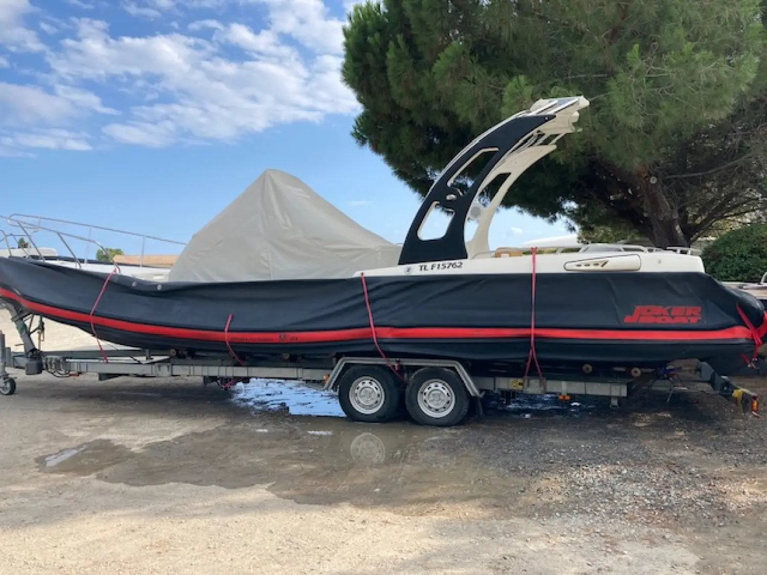 Joker Boat Mainstream 33 — Bateau semi-rigide noir et rouge présenté sur une remorque, vu de profil.