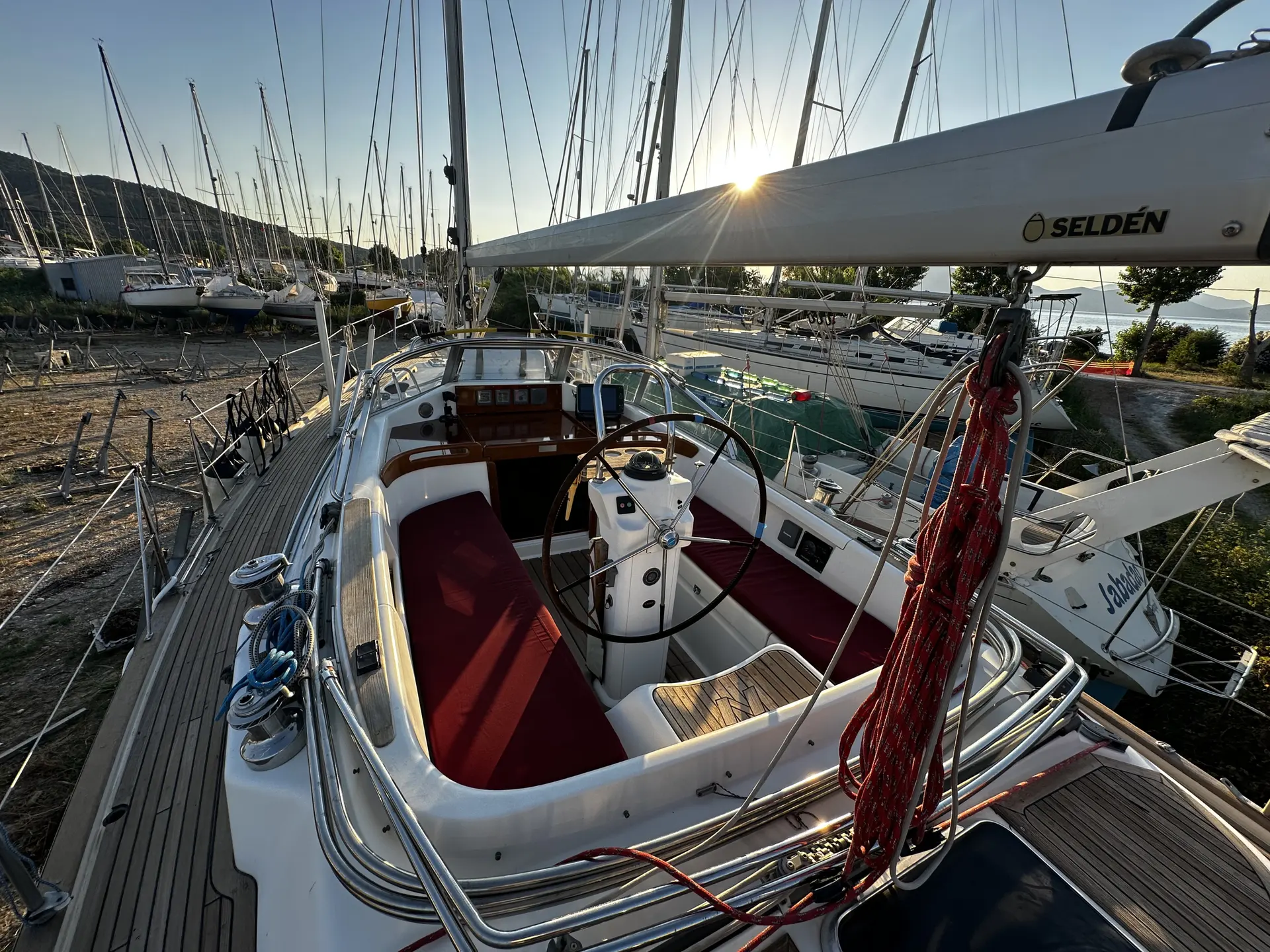 Najad 380 — Vue du cockpit et du pont d’un voilier amarré dans une marina.
