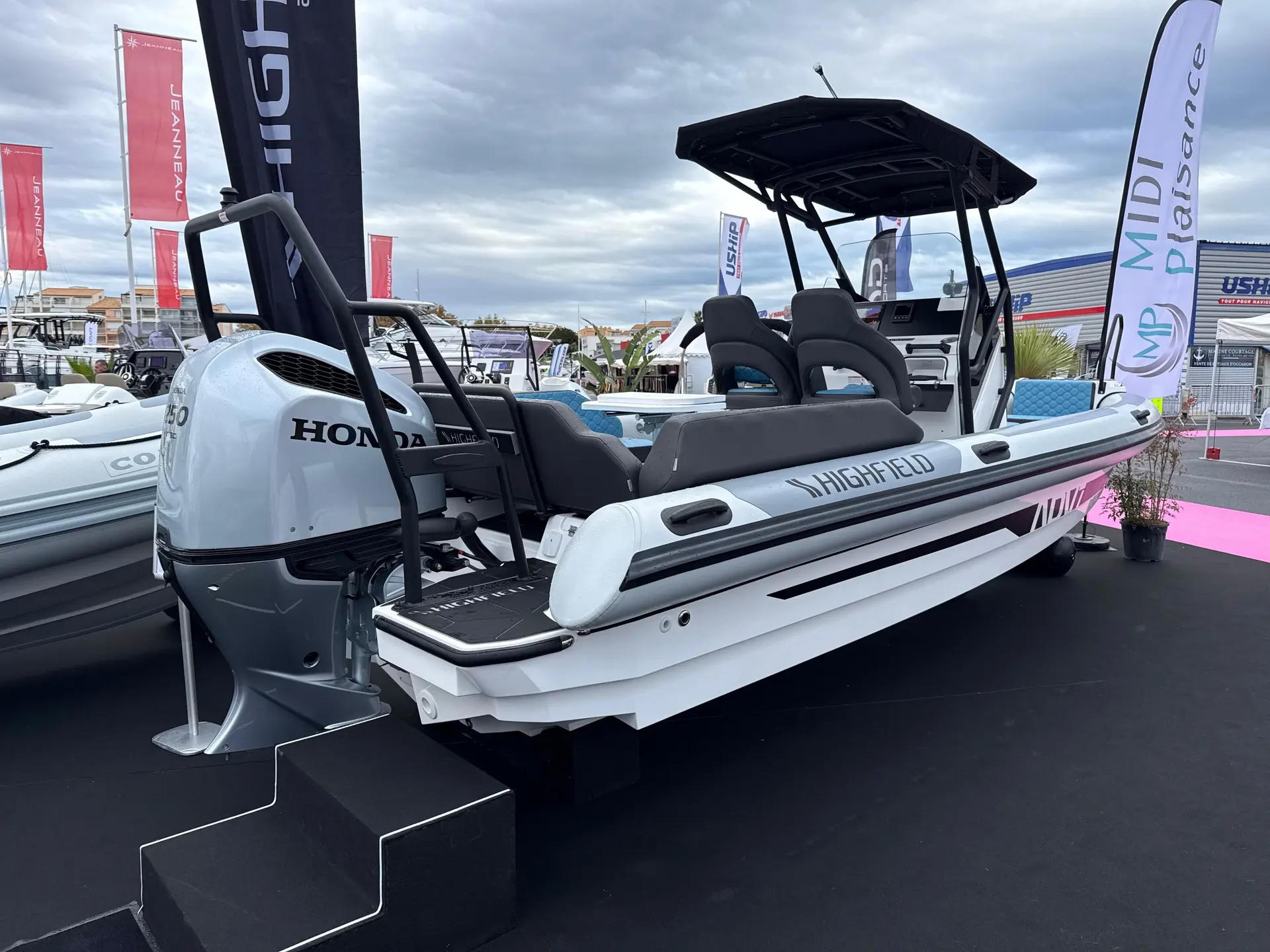 Highfield ADV7 — Bateau pneumatique blanc exposé sur un stand, équipé d’un moteur hors-bord et d’un taud.