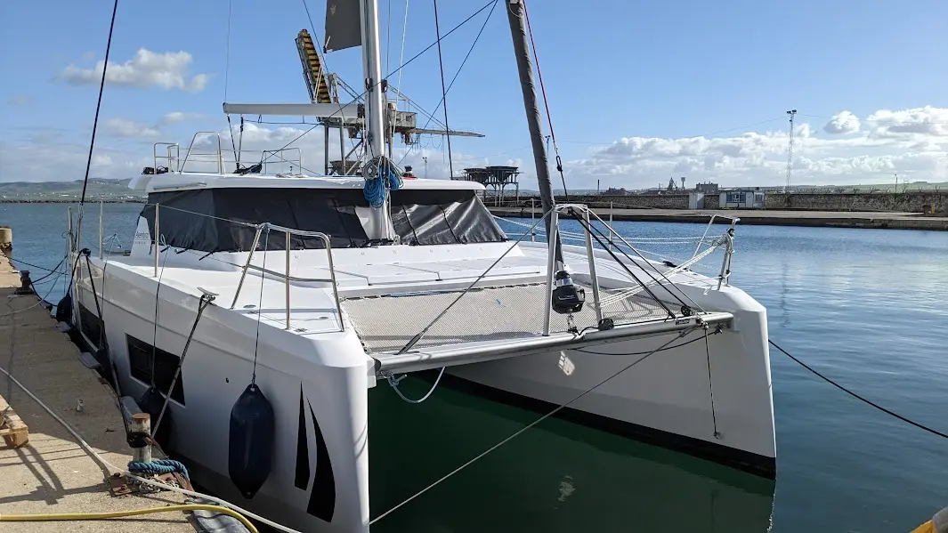 Aventura Yacht Aventura 37 — Catamaran blanc amarré dans un port, vu de trois quarts avant.