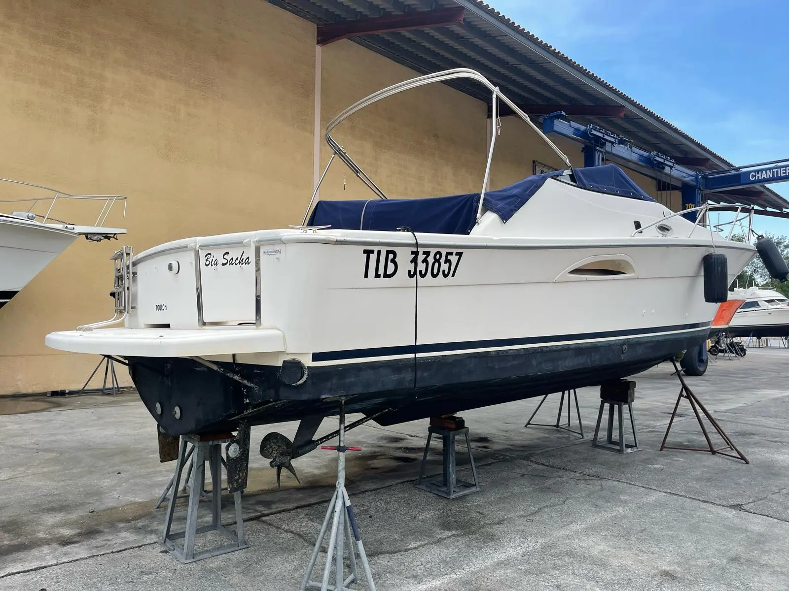 Riviera 3000 — Bateau blanc photographié à terre, sur bers, dans une zone de chantier nautique.