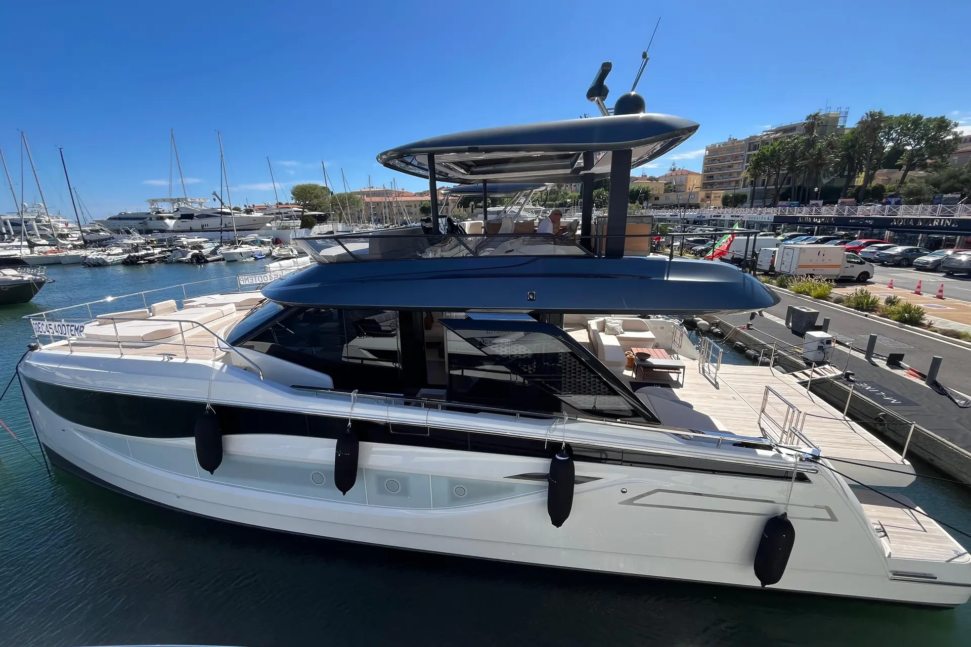 Prestige Yachts M7 — Bateau à moteur blanc et bleu amarré dans un port de plaisance.