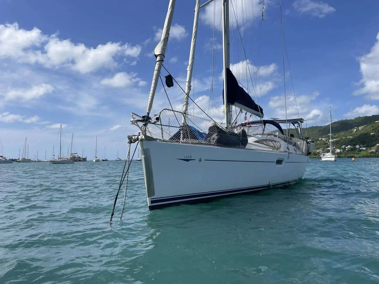 Jeanneau Sun Odyssey 42 DS — Voilier blanc vu de trois quarts avant, au mouillage dans une baie.