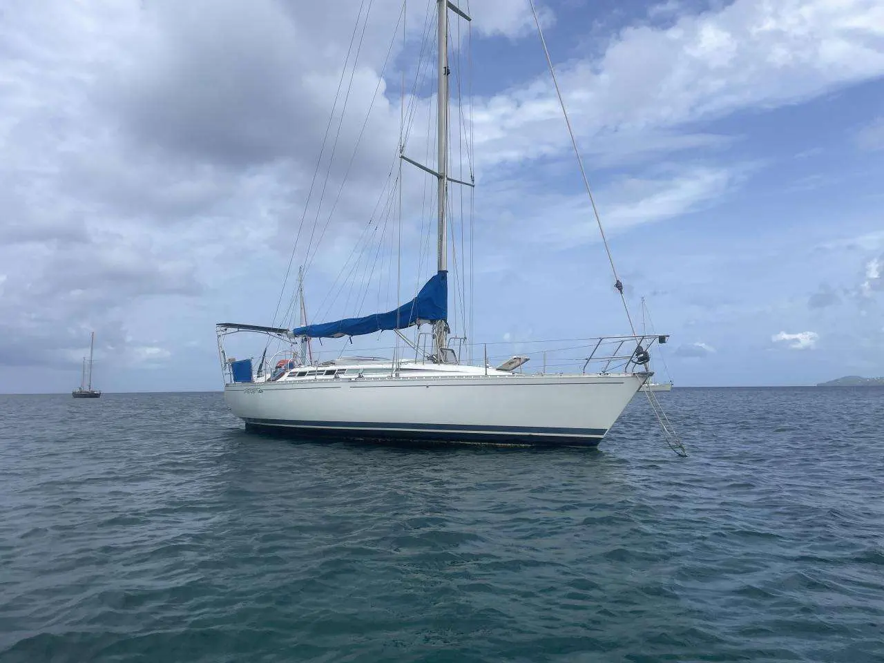 Beneteau First 405 — Voilier blanc photographié au mouillage, vu de trois quarts sur l’eau.