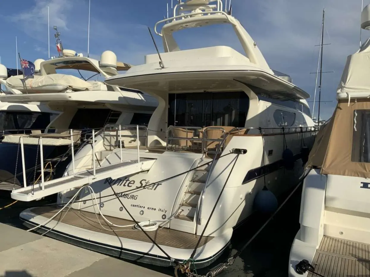 Arno Leopard 24 — Vue trois quarts arrière d’un yacht amarré entre d’autres bateaux.