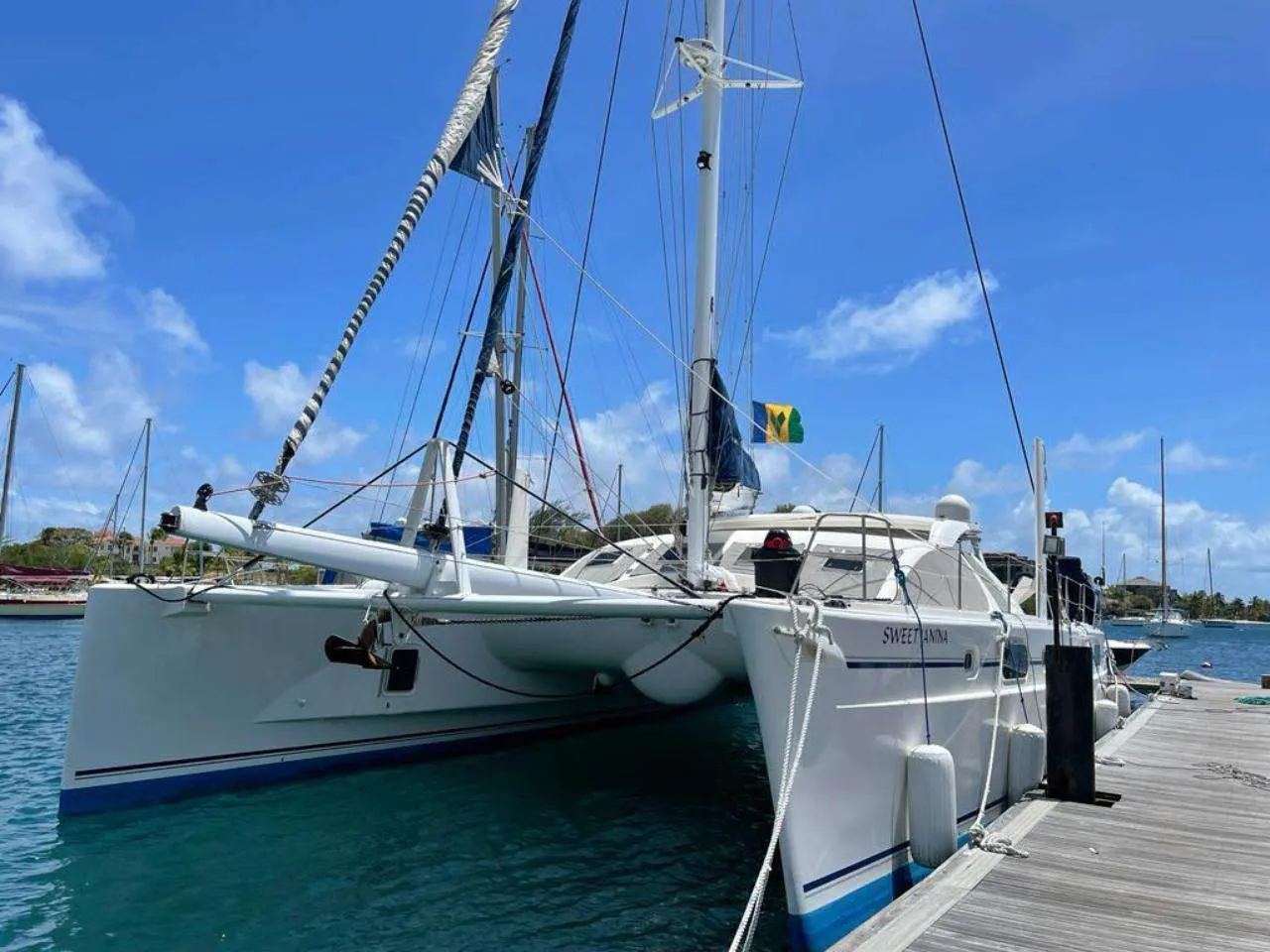 Catana 582 — Catamaran blanc amarré à un ponton, vu de trois quarts par bâbord.