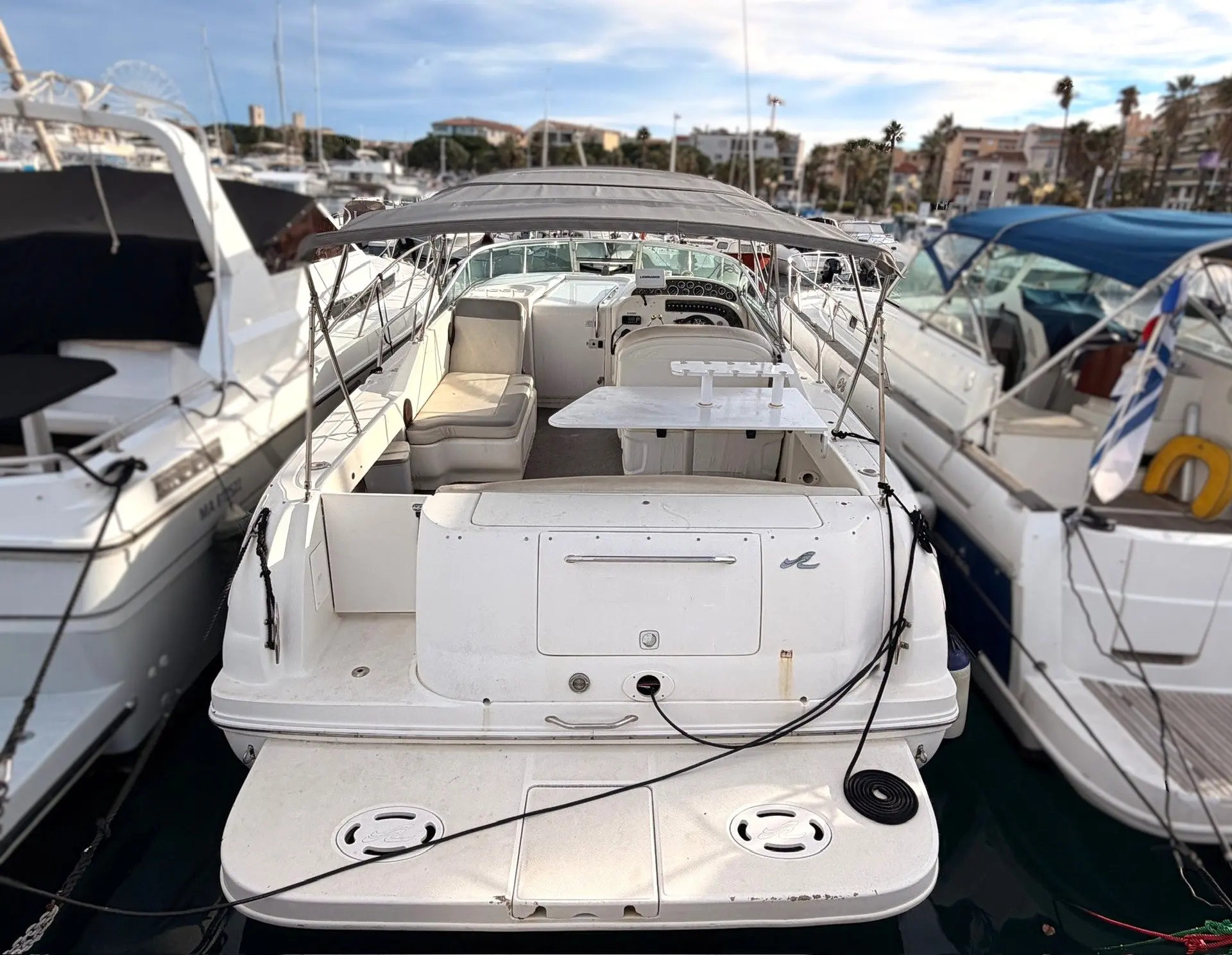 Sea Ray Amberjack 290 — Vue arrière d’un bateau amarré, montrant la plage de bain et le cockpit couvert.