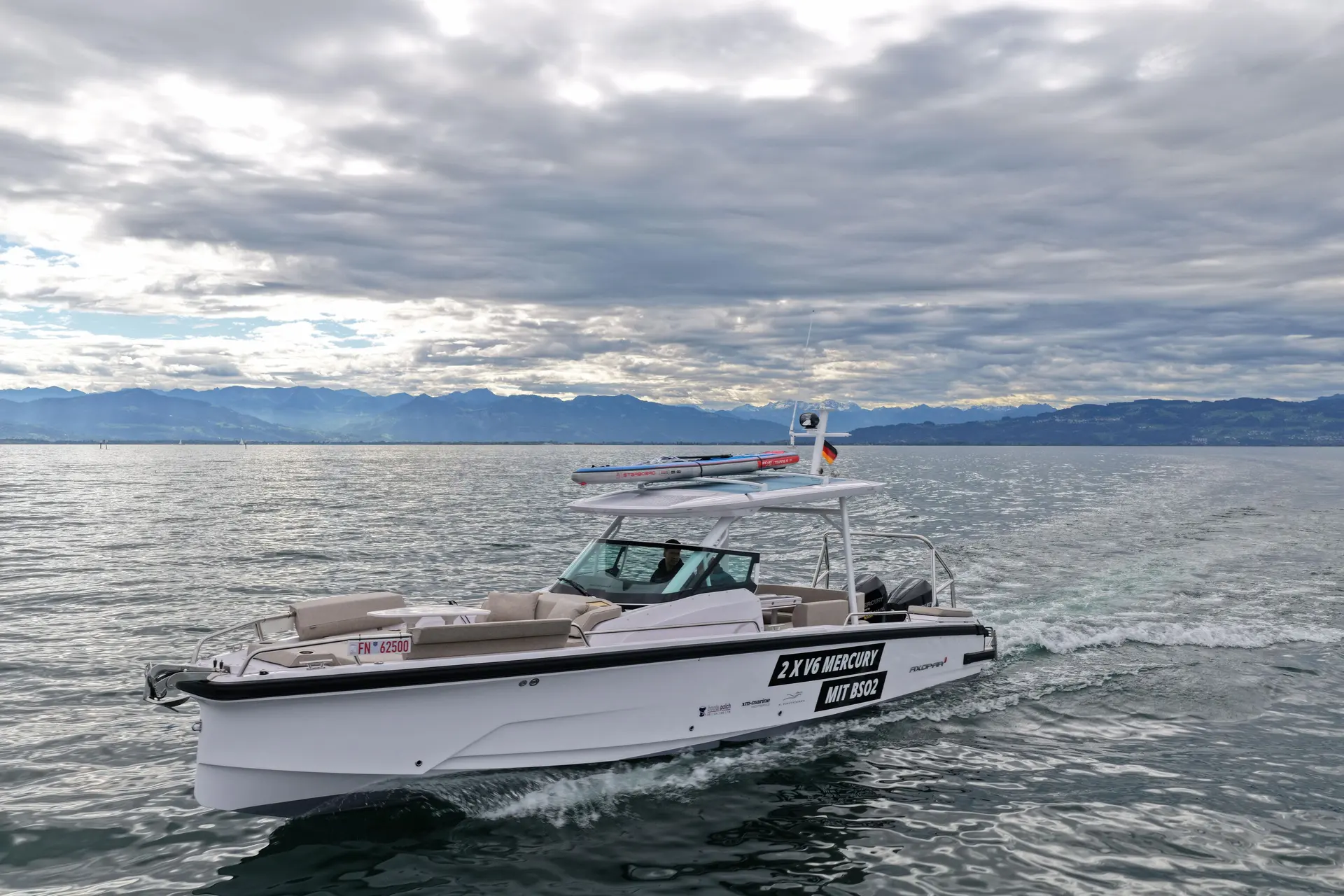 Axopar 29 Sun Top — Bateau à moteur naviguant sur un lac, photographié de trois quarts.