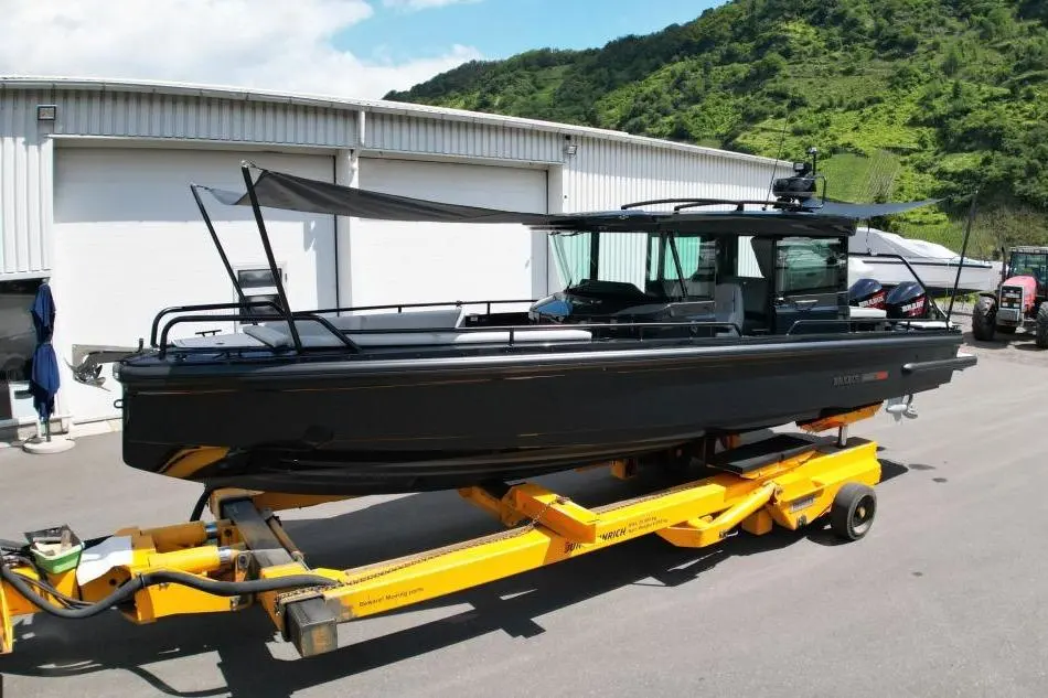 Brabus Marine Shadow 500 — Bateau noir vu de profil sur sa remorque devant un hangar.