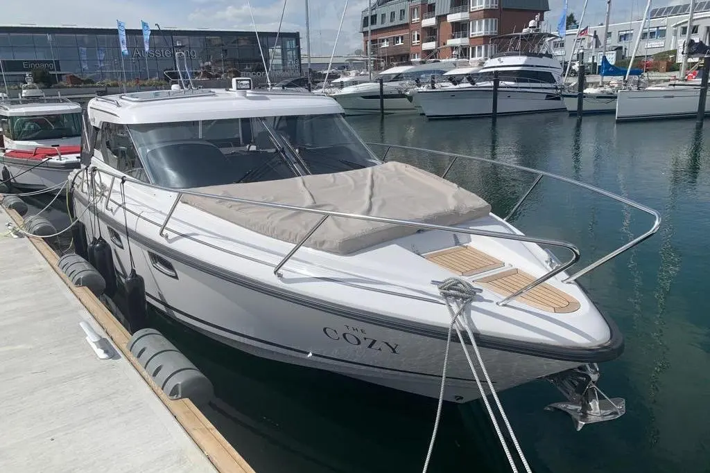 Aquador 28 HT — Bateau à moteur blanc amarré dans une marina, vu de trois quarts avant.