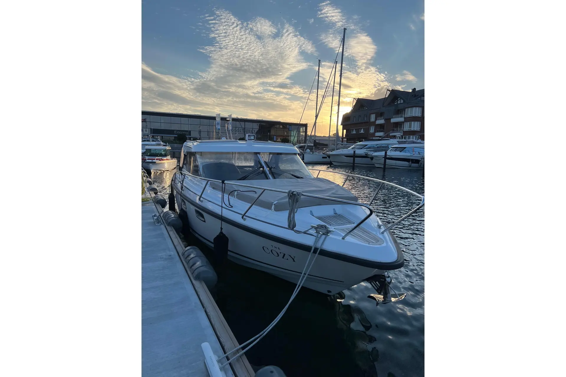 Aquador 28 HT — Bateau à moteur amarré dans une marina, photographié de trois quarts avant.