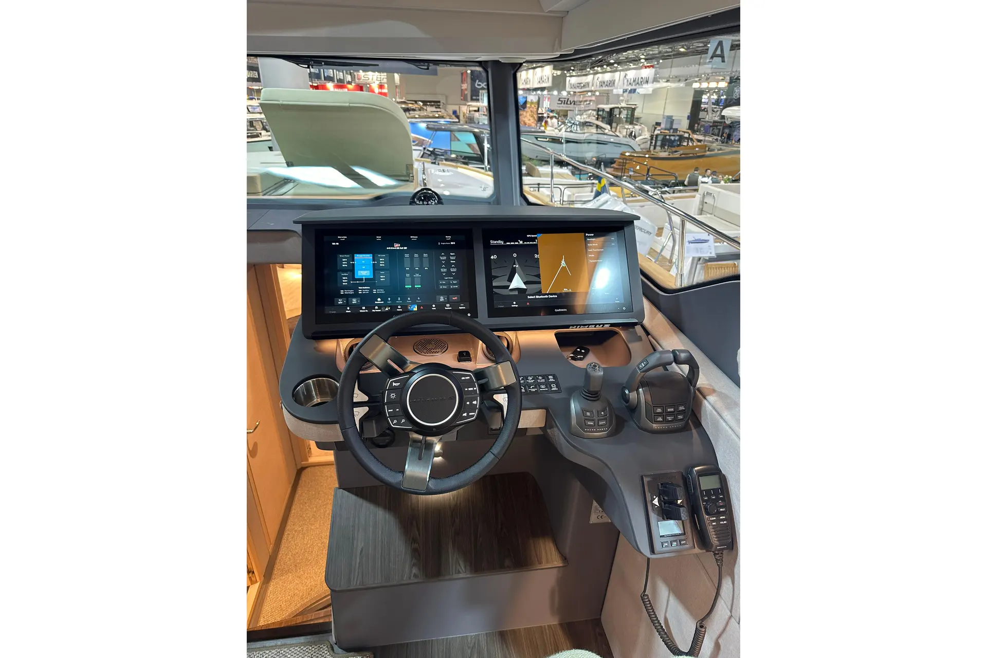 Nimbus 495 — Poste de pilotage avec écrans multifonctions, commandes et volant.