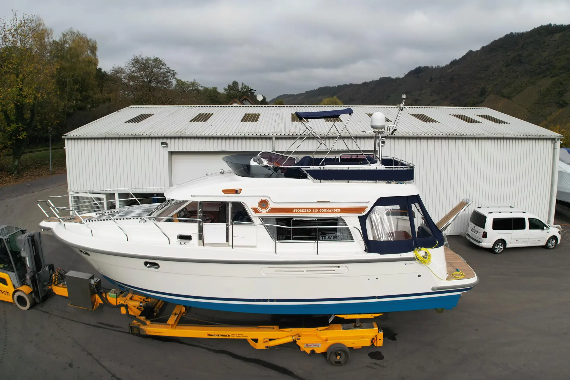 Storebro 410 Commander — Bateau à moteur blanc et bleu photographié à terre sur un chariot de manutention.