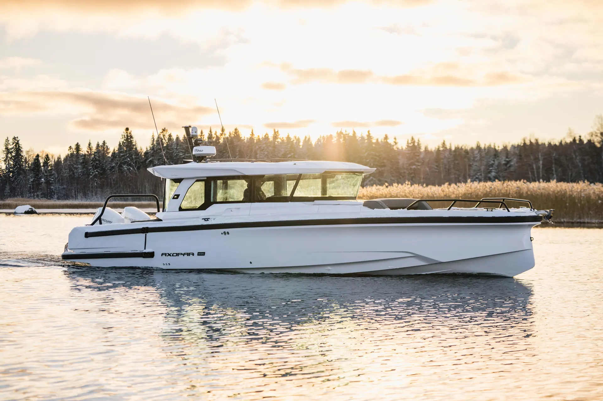 Axopar 38 XC Cross Cabin — Bateau blanc à cabine naviguant sur une eau calme au coucher du soleil.