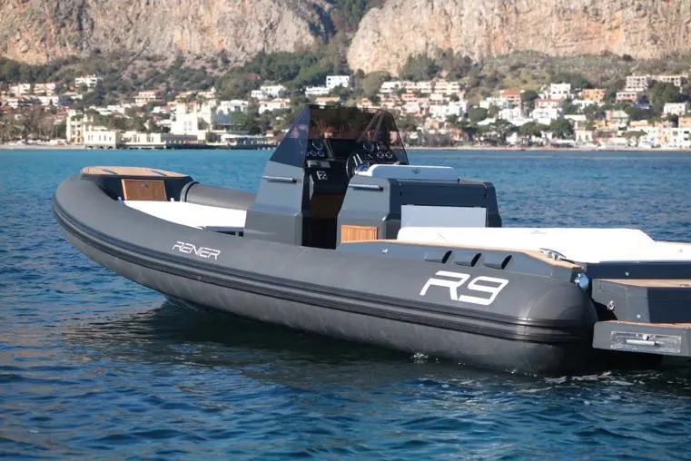 Renier R9 Tourer — Bateau pneumatique gris photographié sur l’eau, avec console centrale et banquette arrière.