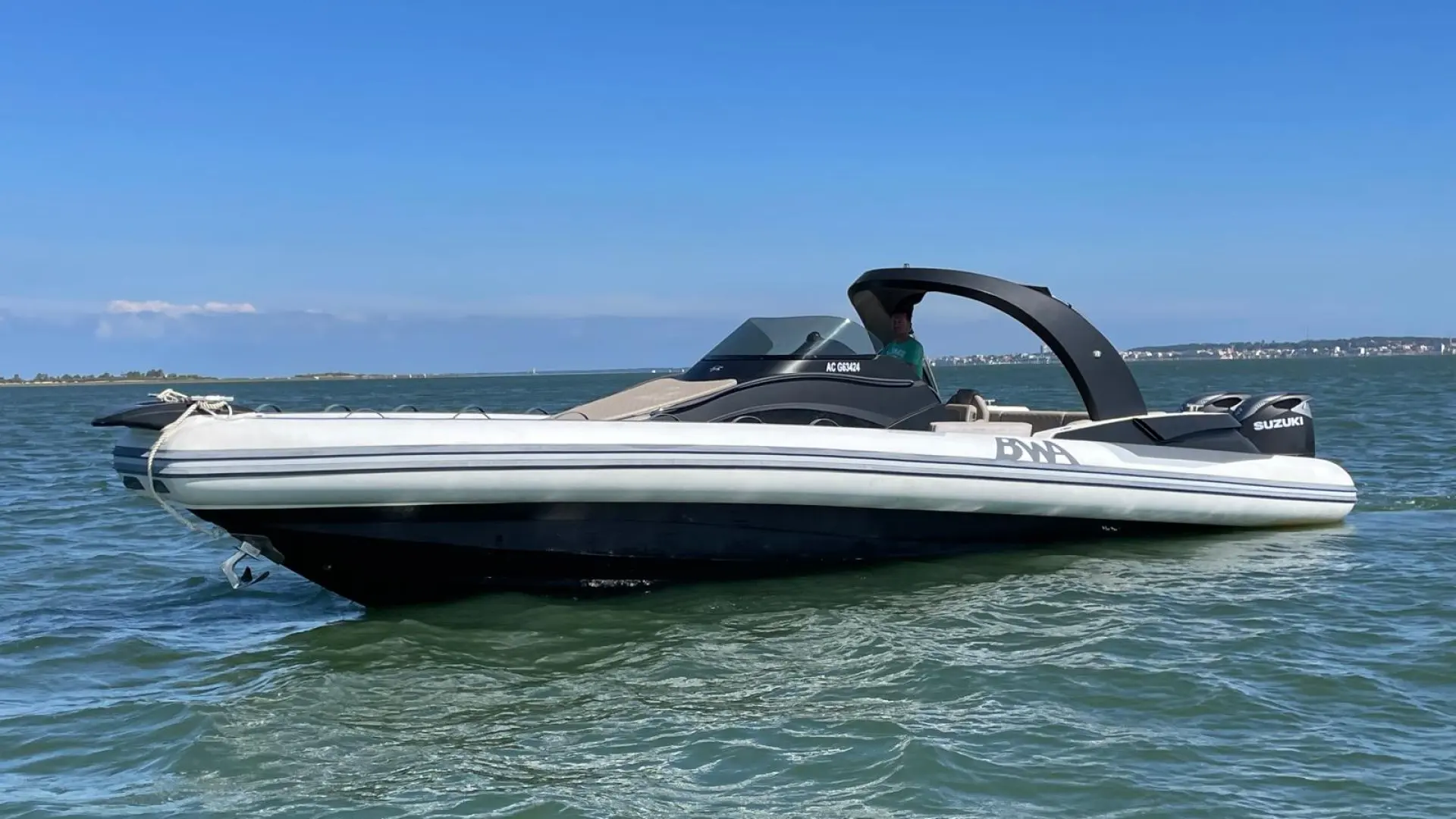 BWA 40 WL — Bateau pneumatique blanc vu de profil sur l’eau, avec console, arceau et moteur hors-bord.